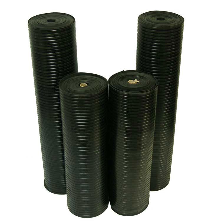 Four Vertically Standing Rolls of Corrugated Wide Rib Rubber Runner Mats, 2 Tall and 2 Short