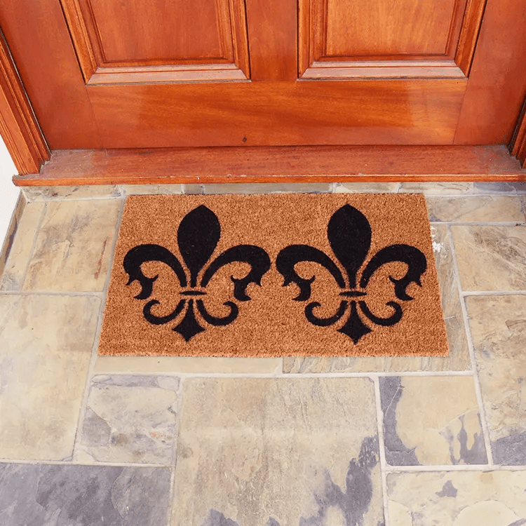 Front View of the Clovis Legend Doormat In Front of Brown Door