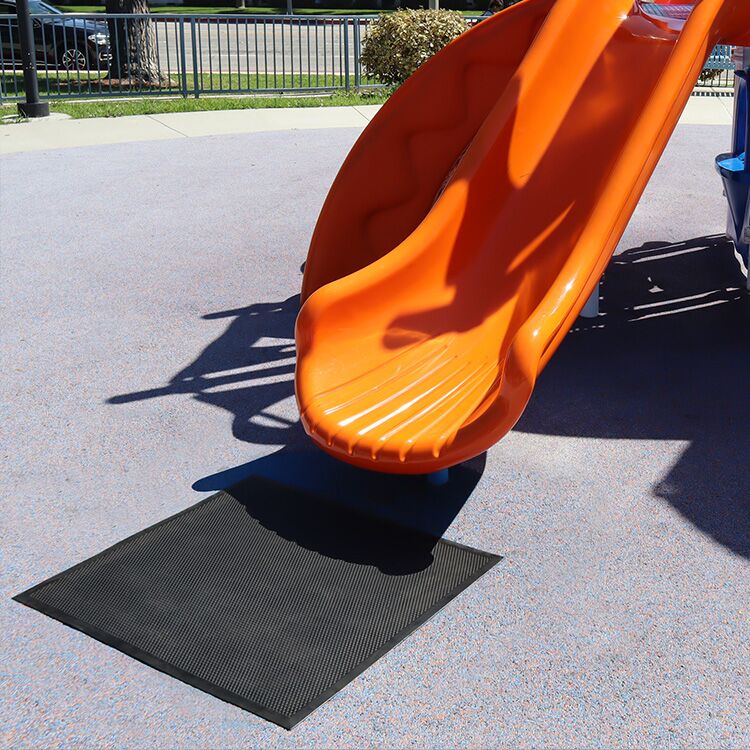 Playground Slide Landing Mat In Front of the End of a Orange Slide Playground Slide Landing Mat In Front of the End of a Orange Slide